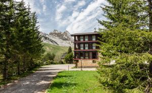 a house on a road with a mountain in the background at Hotel Candanchú in Candanchú