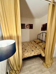 Un dormitorio con una cama con cortinas. en Paris- Disney - Parking privé !PKN! en Torcy