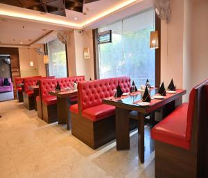 um restaurante com cadeiras e mesas vermelhas e uma janela em Hotel Silver Land New Digha em Digha