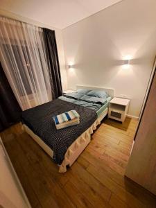 a small bedroom with a bed in a room at 2 kambarių butas ramioje vietoje in Palanga