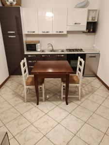 cocina con mesa de madera y 2 sillas en Matteotti 21 en Occhieppo Inferiore