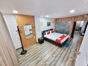 Schlafzimmer mit einem Bett und einem Spiegel in der Unterkunft PuHoR Hotel Plaza Inn in Guwahati
