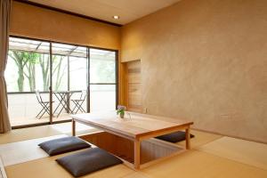 a room with a wooden table and a large window at kamenos Luxury Resort With Beautiful Scenery Hiji in Hiji
