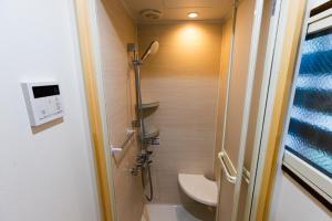 a small bathroom with a toilet and a shower at Yuzawa Onsen Lodge 1min to LIFT A House in Seki