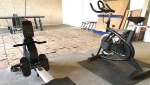 una habitación con un gimnasio con una bicicleta y una cámara en La Saulainière, en Pontlevoy