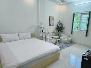 a bedroom with a white bed and a window at Góc Hải Phòng Homestay Q4 in Ho Chi Minh City