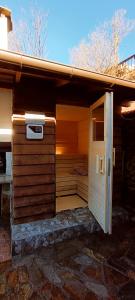 an outdoor sauna with an open door on a house at Guest House Chepelare in Chepelare