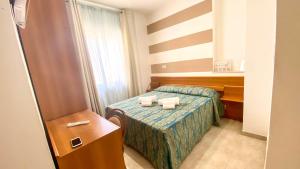 Una habitación de hotel con una cama con dos toallas. en Hotel Alba Living Room en Rodi Garganico