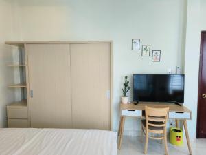 ホーチミン・シティにあるGóc Hải Phòng Homestay Q4のベッドルーム1室(ベッド1台、デスク、テレビ付)