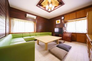 sala de estar con sofá verde y mesa en Yufuin Kurokiya - Vacation STAY 85694 en Yufuin