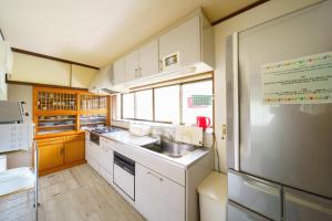 una cucina con armadi bianchi e lavandino di Yufuin Kurokiya - Vacation STAY 85694 a Yufu