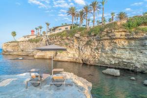 twee stoelen en een parasol op het strand bij Minareto in Siracusa