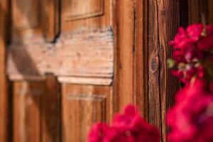 une porte en bois avec un bouquet de fleurs roses dans l'établissement Villa Straussengut, à Bad Aussee