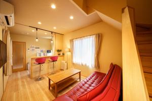 a living room with a red couch and a table at Chachamaru no Oyado - Vacation STAY 85728 in Yufuin
