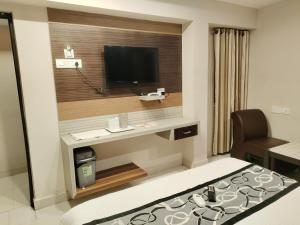 a hotel room with a desk and a television at Santhi Bhavan, Chennai Central in Chennai