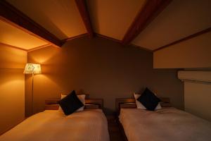 2 camas en una habitación con luces en la pared en Chachamaru no Oyado - Vacation STAY 85728, en Yufu