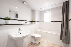 a white bathroom with a sink and a toilet at Two Bed, Two bath, Apartment with Parking Space in Colchester