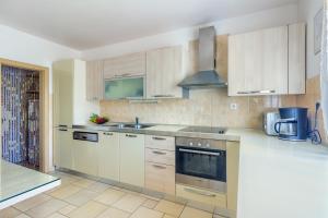 a kitchen with white cabinets and a sink at Villa My peace in Sičane