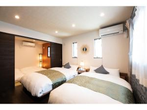 2 camas en una habitación de hotel con en BEPPU NO YU SORA - Vacation STAY 87966 en Beppu