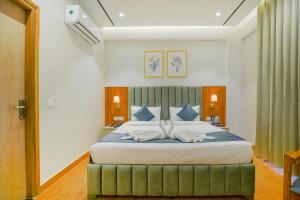a bedroom with a large bed with a green ottoman at Hotel West Inn Premium in Kharar