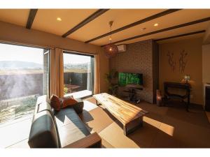 un soggiorno con divano e una grande finestra di YUHUROTEN YOJYOU NO BI - Vacation STAY 87032 a Yufu