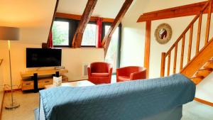 uma sala de estar com um sofá e uma televisão em Gite 3 étoiles dans une grange rénovée - Cantal Emotions Valette - Auvergne em Valette
