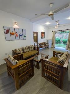 a living room with couches and tables at Old Bridge Riverside Hotel in Kitulgala