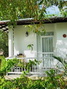 un porche de una casa blanca con ventana en Villa Olga, en Unawatuna