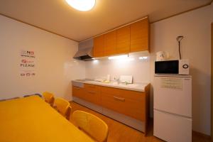 a small kitchen with a table and a refrigerator at Takanoya Tsuki - Vacation STAY 91942 in Yufuin