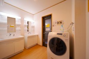 a washing machine in a bathroom with two sinks at Takanoya Tsuki - Vacation STAY 91942 in Yufuin