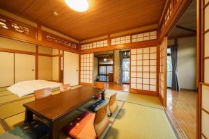 a room with a table and chairs and a bed at Yumeguri no yakata Yoshinozakura - Vacation STAY 83043v in Yufuin