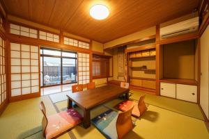 Habitación con mesa, sillas y TV. en Yumeguri no yakata Yoshinozakura - Vacation STAY 83043v, en Yufu