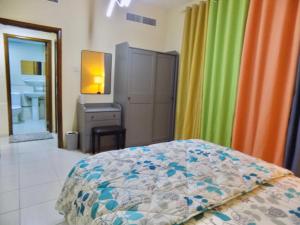 a bedroom with a bed and colorful curtains at Al Canary Aparts in Ajman 