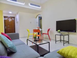 a living room with a couch and a flat screen tv at Al Canary Aparts in Ajman 