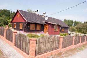 una pequeña casa roja detrás de una valla de madera en chalupa u Pinkasů, en Střítež