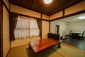 a living room with a table and a window at Yufuin Ekimae Yado Kachofugetsu - Vacation STAY 88189v in Yufuin