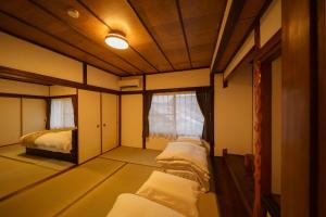 a room with two beds and a window at Yufuin Ekimae Yado Kachofugetsu - Vacation STAY 88189v in Yufuin