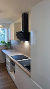 uma cozinha com armários brancos e um forno com placa de fogão em Jolie appartement proche bords de Loire em Orléans