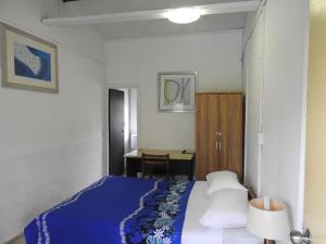 una camera con letto blu e scrivania di Olivias Accommodation ad Apia