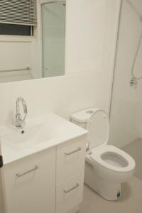 A Spacious Room with Private Toilet في غولد كوست: حمام مع مرحاض ومغسلة ومرآة