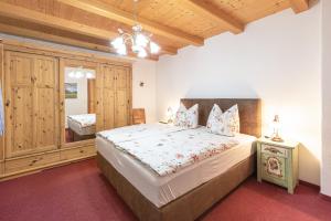 ein Schlafzimmer mit einem großen Bett und einer Holzdecke in der Unterkunft Gästehaus Oberland in Wallgau