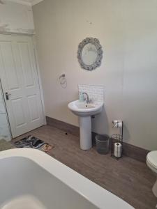 een witte badkamer met een wastafel en een toilet bij 13 on Eiland in De Kelders