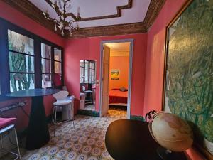 Cette chambre aux murs roses comprend une table et un lit. dans l'établissement Fabrica de Sueños, à Gandía