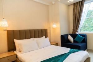 Moodhukoe في مدينة ماليه: غرفة نوم بسرير وكرسي ازرق