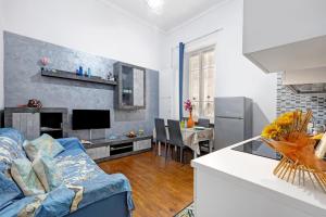 皮耶特拉利古雷的住宿－Stella Marina - By Ligooria，一间带蓝色沙发的客厅和一间厨房