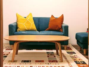 a blue couch with pillows and a wooden coffee table at Kiyomizu Donguri An in Kyoto +23 photos