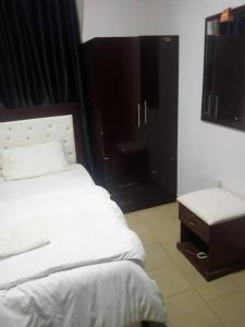 a bedroom with a white bed and a table at Dovan Lodge Enugu in Enugu
