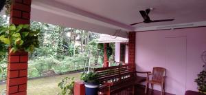 a porch with a bench and a window at Runnin Airport - Homestay in Gurpur