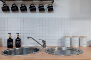 a kitchen counter with a sink and bottles on it at Urban Oasis: Heart of City by Train in Leeds +22 photos