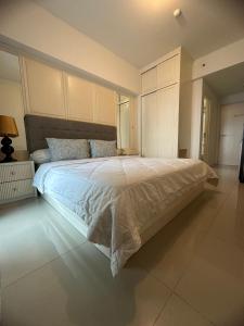 ein Schlafzimmer mit einem großen Bett mit weißer Bettwäsche in der Unterkunft Tanglin Orchard Apartment by Kondoku in Lontar
